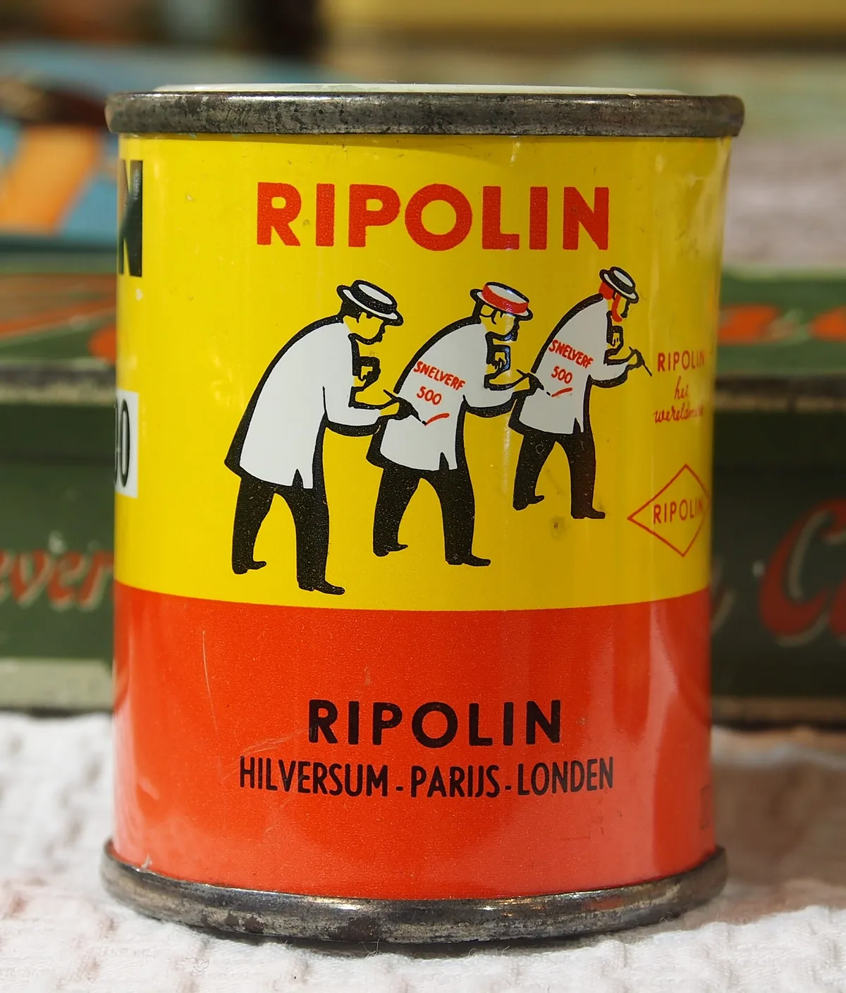 Can of Zinsser B-I-N primer with a roller and paint tray on a drop cloth