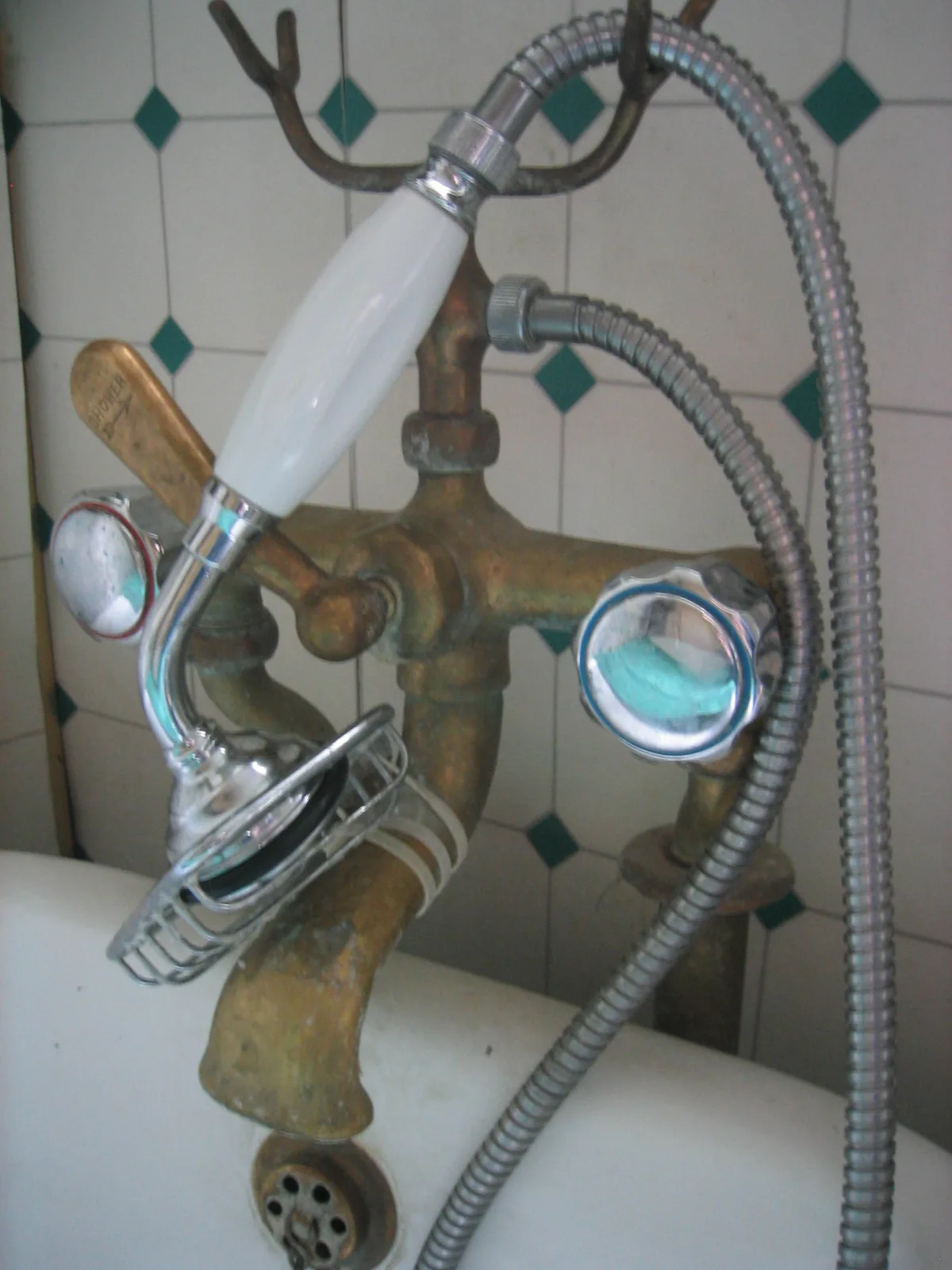 Close-up of a deteriorated caulk line where bathtub meets tile wall, showing a visible gap